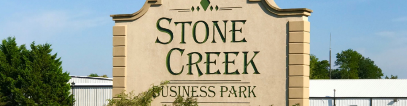 A photo of an outdoor sign for the Stone Creek Business Park.